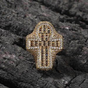 Detailed close-up of golden cross ring with pavé-set cubic zirconia on charcoal background