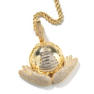 Macro detail of gold hip hop pendant featuring iced-out zircon hand holding world globe