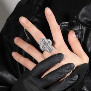 Close-up of hip hop style cross ring with sparkling cubic zirconia on a black background