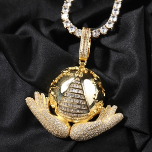 Close-up of hip hop gold necklace with a globe pendant held by stone-set hands