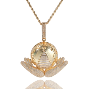 Macro shot of hip hop pendant featuring gold pyramid all-seeing eye and globe with 5A zircon