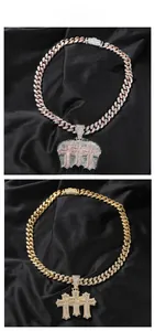 Detail of hip hop Cuban link necklaces with iced-out triple cross pendants on black silk