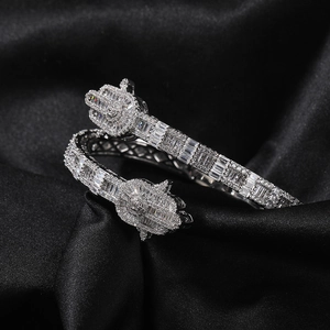 Macro shot of a silver Hamsa Hand open bangle with sparkling cubic zirconia on black silk