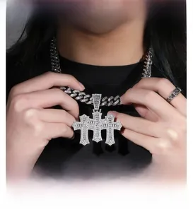 Macro detail of iced-out silver triple cross pendant and thick cuban chain set