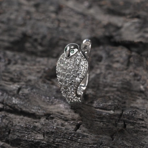 Dettaglio dell'anello cobra in argento con zirconi bianchi e occhi in gemma verde
