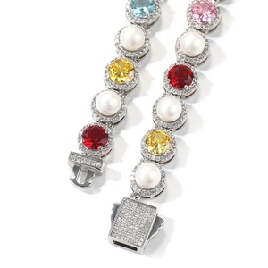 Detailed close-up of colorful gemstones and white pearls on a silver-tone luxury bracelet