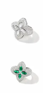 Nahaufnahme von Kleeblatt-Ringen mit Zirkonia-Pavé und grünem Edelstein im Zentrum