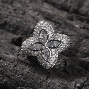 Makroaufnahme von Silberring mit Zirkonia-Blüten und Pavé-Diamanten auf schwarzem Hintergrund