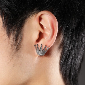 Gros plan d'un clou d'oreille couronne en argent avec zircons brillants sur un homme