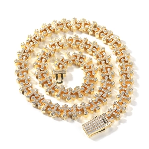 Macro view of gold-plated hip-hop necklace with iced-out cross links and crystal clasp