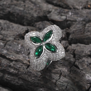 Makroaufnahme von Kleeblatt-Ring mit smaragdgrünen Steinen und funkelndem Zirkon-Pavé