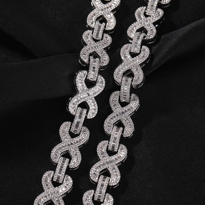 Makrodetail einer silbernen Hip-Hop-Kette mit Infinity-Gliedern auf schwarzer Seide