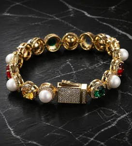 Detail of gold-plated bracelet with white pearls, colorful gemstones and pavé box clasp