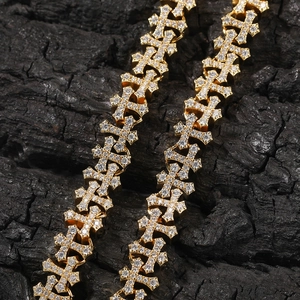 Macro detail of iced-out gold cross chain links with micro-paved white zircon stones
