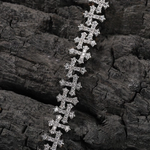 Macro detail of silver hip hop cross chain necklace with iced out sparkling rhinestones