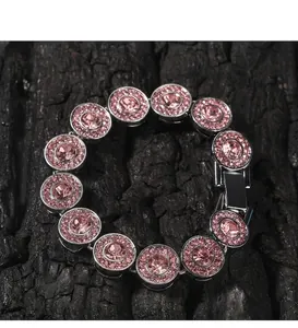 Makroaufnahme von Silberarmband mit rosa runden Steinen auf dunklem Holzgrund