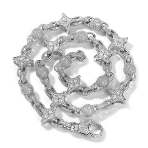 Dettaglio macro della collana con stelle argentate e perle con pavé di zirconi
