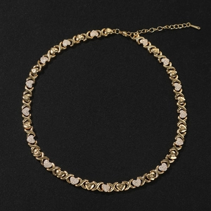 Detailed macro view of gold-plated XOXO heart chain necklace with sparkling cubic zirconia