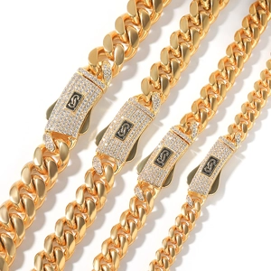 Detalle de cuatro cadenas cubanas doradas con cierres de cristales incrustados y logotipos
