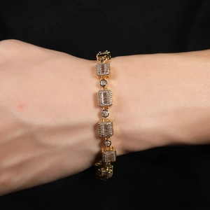 Close-up of gold plated link bracelet with cubic zirconia on wrist in black background