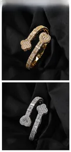 Detail of clover and heart bangle set with cubic zirconia stones on black silk background