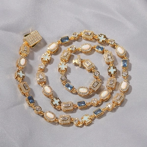 Macro shot of gold-plated bracelet with opal stones, blue crystals and cross charms