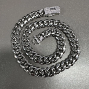 Detalle de cadena cubana plateada pulida con cierre de caja de diamantes y el logotipo S