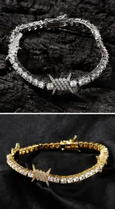 Close-up of gold and silver hip-hop tennis bracelets with iced out thorn wire designs