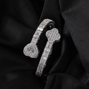 Detail of hip-hop clover and heart open bangle with cubic zirconia on black silk