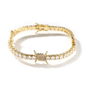 Close-up of golden tennis bracelet with thorn wire link and round cubic zirconia stones