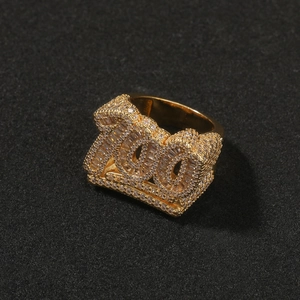 Dettaglio di un anello hip hop con zirconi incastonati a forma di numero 100 dorato