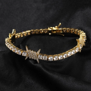 Macro shot of hip hop tennis bracelet with gold barbed wire charm and zircon inlay