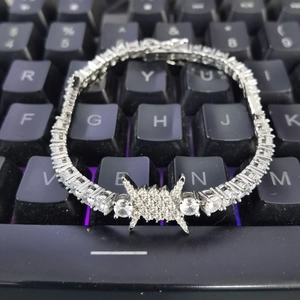 Macro detail of silver hip hop tennis bracelet with zircons on mechanical keyboard