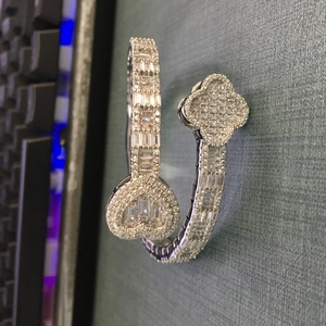 Macro detail of silver-finish hip hop clover and heart bangle with cubic zirconia stones