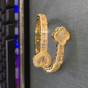 Close-up of gold plated clover and heart bracelet with shimmering zircon stones