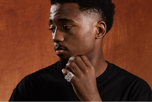 Primo piano dell'anello hip-hop da uomo in argento con design numero 100 pavé sul dito