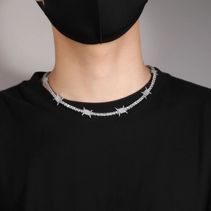 Detail of hip hop tennis chain necklace with thorn accents and white zircons on a male model