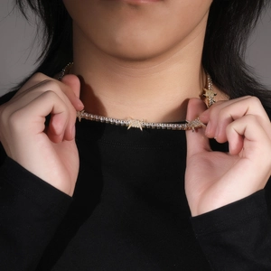 Detail of hip hop tennis necklace featuring gold thorns with cubic zirconia on a male model