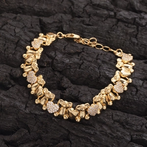 Detail of bear and heart bracelet links with micro-paved white zircons on golden finish