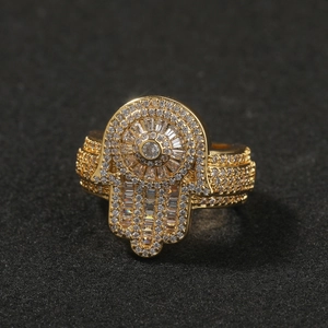 Vue macro de la bague main de Fatma dorée ornée de zircons pavés sur fond noir