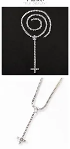 Detailed view of silver cross pendant with teardrop zircon on elegant tennis chain necklace
