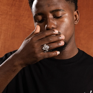 Détail d'une bague hip hop en argent avec zircons sertis sur la main d'un mannequin homme