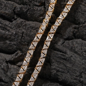 Détail d'une chaîne tennis dorée avec des pierres de zircone en taille triangle