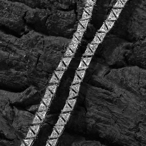 Vue macro de pierres de zircon triangulaires de qualité sur une chaîne tennis argent