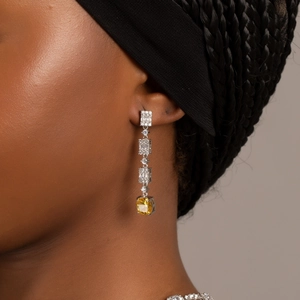Elegante silberne Ohrringe mit gelben Kristallen an einem Model für Bankette