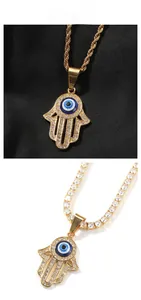 Dettaglio del ciondolo Mano di Fatima con occhio blu e strass bianchi scintillanti