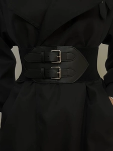 Close-up of black elastic corset belt with double silver metal buckles on a trench coat