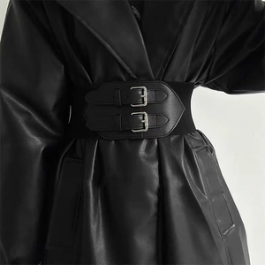 Detail of black wide elastic waist belt with double silver buckles on faux leather
