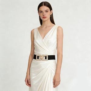 Détail d'une large ceinture élastique noire avec boucle dorée en strass sur une robe