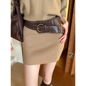 Détail de la large ceinture en cuir marron vintage avec clous en laiton et boucle ronde